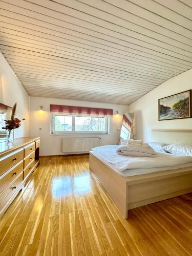 una grande camera da letto con un grande letto e pavimenti in legno di Central Villa with Garden a Lubiana