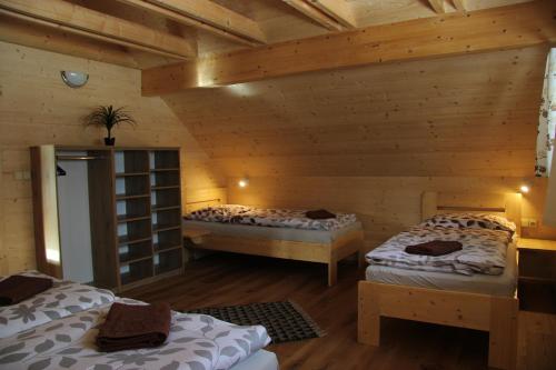 a room with two beds in a log cabin at U Křížku in Modrava