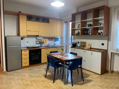 cocina con mesa de madera y sillas azules en Metro Suite Milano, en Milán