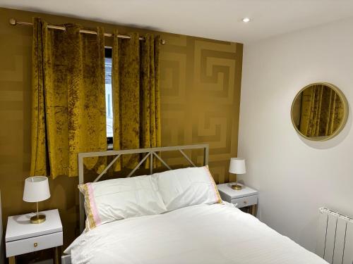 1 dormitorio con 1 cama con cortinas amarillas y espejo en Versace The Malt House, en Burton upon Trent