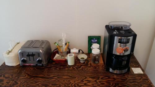 a coffeemaker and coffee maker on a wooden table at Greem Guesthouse in Jeonju