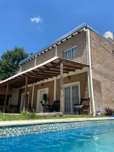 ein Haus mit Pool davor in der Unterkunft La Quinta San Cayetano in Laguna Brava