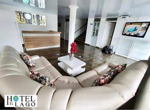 a living room with a white couch and a table at Hotel El Lago in Mocoa