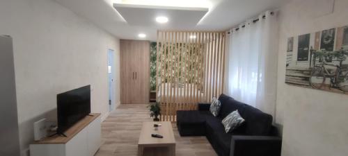 ein Wohnzimmer mit einem Sofa und einem TV in der Unterkunft Apartamento Centro A in San Sebastián de los Reyes