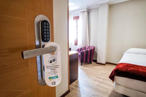 a door with a sign in a hotel room at Hotel Alda Bonaval in Santiago de Compostela