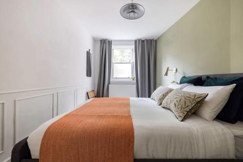 ein Schlafzimmer mit einem großen Bett mit einer orangen und weißen Decke in der Unterkunft Contemporary central flat in Clerkenwell Green in London
