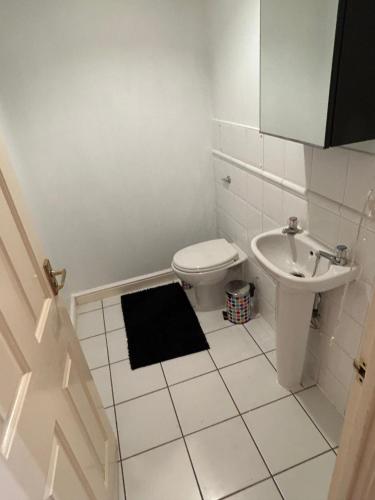 a white bathroom with a toilet and a sink at Lovely 1 bedroom apartment in East London in London