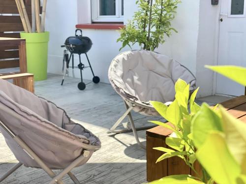 um pátio com uma cadeira, plantas e comodidades para churrascos em Voyage au Canal - Parking Clim Netflix Amazon em Montauban