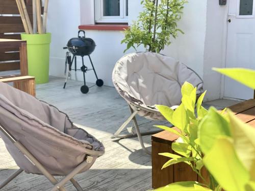 a patio with a chair and plants and a grill at Voyage au Canal - Parking Clim Netflix Amazon in Montauban