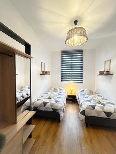 une chambre avec deux lits et un miroir dans l'établissement Voyage au Canal - Parking Clim Netflix Amazon, à Montauban