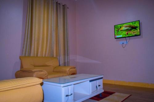 - un salon avec un canapé et une télévision murale dans l'établissement Briston Hotel - Mugumu, à Mugumu