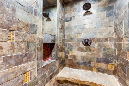 a walk in shower with a stone wall at 2 Mi to UA Central Fayetteville Home with Patios in Fayetteville