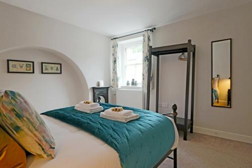 a bedroom with a bed with towels on it at Beautiful Character Cottage in Milford