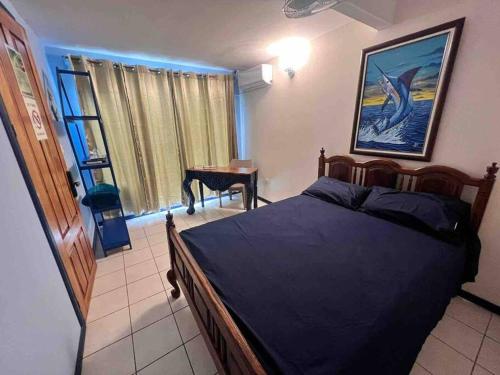 a bedroom with a bed and a table and a window at Puntarenas, Apartamento Mateo in Puntarenas