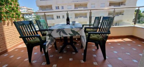 einen Tisch mit 4 Stühlen und eine Flasche Wein auf dem Balkon in der Unterkunft Nice apartment in Puerto Marina in Benalmádena