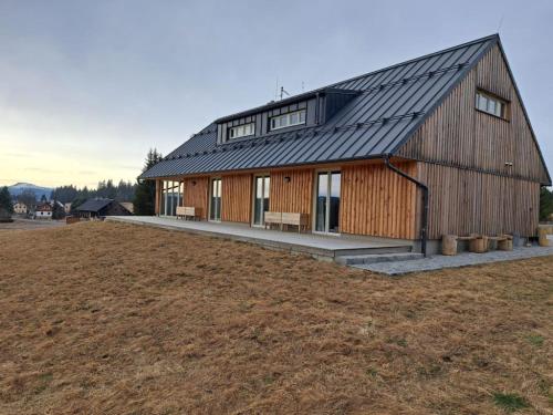 a barn with a metal roof on a field at Ubytování U Křížku in Modrava
