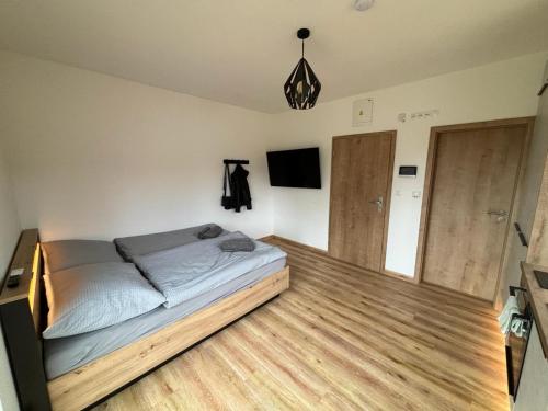 Schlafzimmer mit einem Bett und Holzboden in der Unterkunft Apartmány u pláže Lipna - Malé Lipno in Černá v Pošumaví