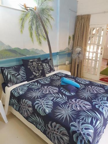 a bedroom with a bed with a palm tree at Shangrila-innibos Country Lodge in Hartbeespoort