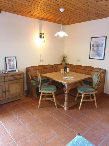 a dining room with a wooden table and chairs at Ferienhaus Schäfer - Apartments - Wintersports - Family holiday - Holiday with your dog - Rural & Scenic in Flattnitz