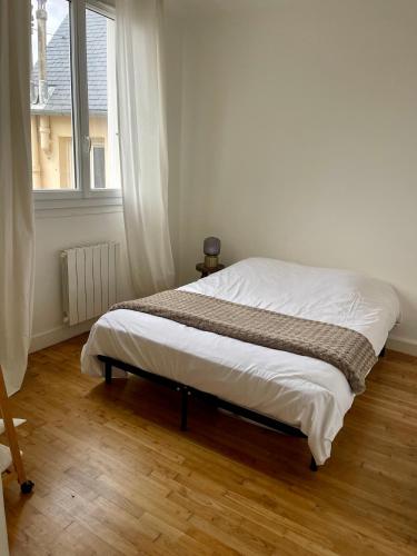 een bed in een witte kamer met een raam bij Le 30 Rennais - T4 en plein centre ville in Rennes