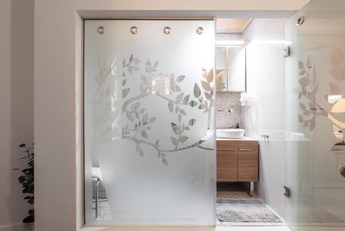 uma casa de banho com um chuveiro e uma porta de vidro em Couple-in magical suite with jacuzzi em Tessalônica