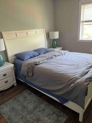 a bedroom with a large bed with two night stands at Blue door loft upper apartment in Thorold