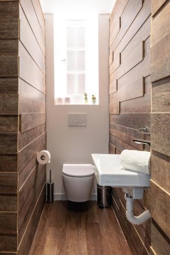 a bathroom with a white toilet and a sink at Couple-in magical suite with jacuzzi in Thessaloniki