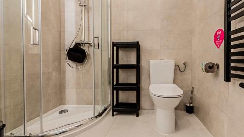 een badkamer met een toilet en een douche bij VacationClub - Apartamenty Zakopiańskie Apartament 16 in Zakopane