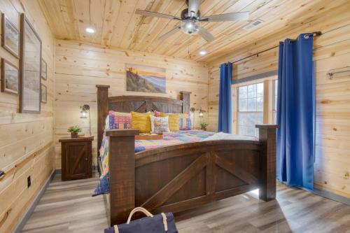 a bedroom in a log cabin with a bed and blue curtains at Pink Pines AvantStay Luxury Aesthetic Dream Home Indoor Pool Hot Tub in Pigeon Forge