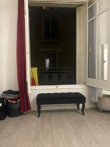 un banc assis devant une fenêtre dans l'établissement Grand studio 30M2 Asnières sur Seine Centre-Ville, à Asnières-sur-Seine
