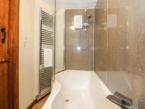 a bathroom with a bath tub and a shower at 5 Melinda Cottages in West Runton