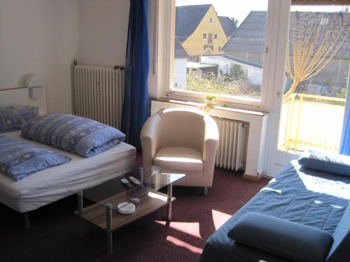 Zimmer mit einem Bett, einem Stuhl und einem Fenster in der Unterkunft Gasthaus Rogge in Lemgo