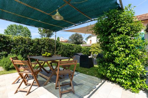 un tavolo e sedie sotto un ombrellone su un patio di Beach House with private garden a Marina di Pietrasanta