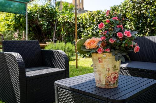 un vaso di fiori su un tavolo con due sedie di Beach House with private garden a Marina di Pietrasanta