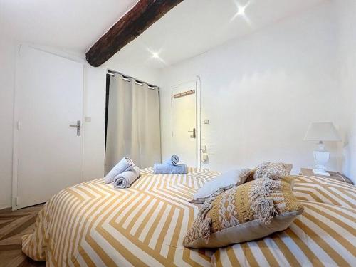 une chambre avec un lit avec des oreillers dessus dans l'établissement L'Esprit du Vieux Port- Central & Paisible - Les Frères de la Loc, à Marseille