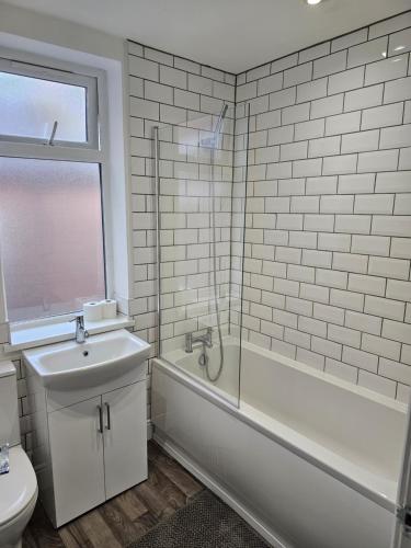 uma casa de banho com um WC, uma banheira e um lavatório. em Stylish & Quiet Space em Manchester