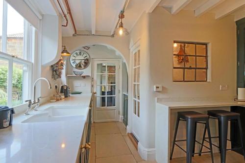 a kitchen with a sink and a clock on the wall at Beautiful Character Cottage in Milford