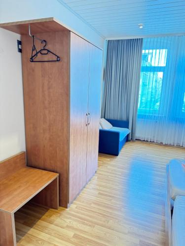 a living room with a cabinet and a blue couch at Pension Sonnenschein in Halle an der Saale