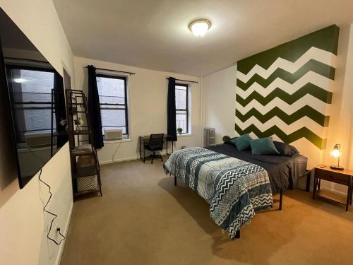 a bedroom with a bed and a striped wall at Comfy Guest House by Columbus Circle in New York