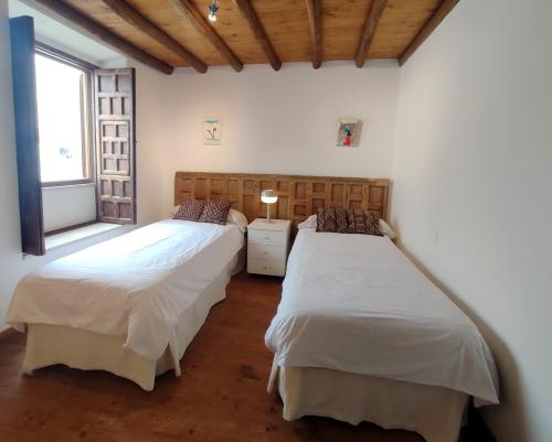 two beds in a room with a window at Casa Vila do Bispo in Vila do Bispo