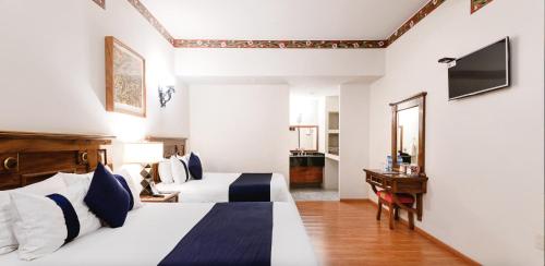 a hotel room with two beds and a desk at CASA MAYES in Pátzcuaro