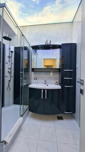 a bathroom with a sink and a shower at RoApart Riva Lake Studiouri si Apartamente 2-3 camere cu vedere lac -parcare privata in Mamaia