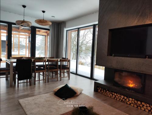 a living room with a fireplace and a dining room at Cieślówka in Leżajsk