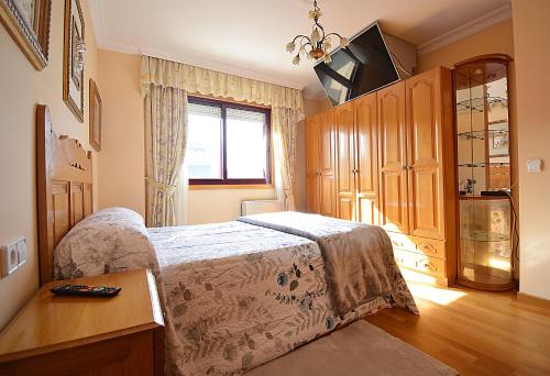 1 dormitorio con 1 cama, TV y ventana en Apartamento As Carolinas, en Vilagarcía de Arousa