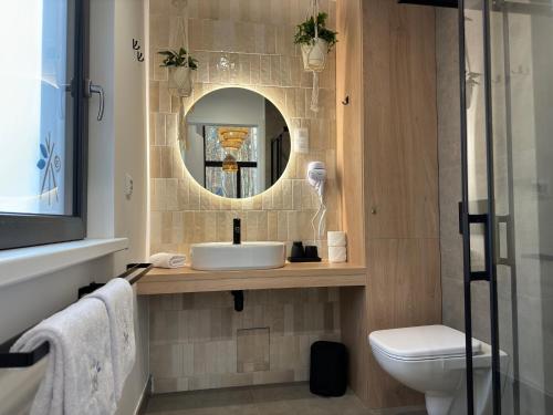 een badkamer met een wastafel, een toilet en een spiegel bij Patyki - Las Możliwości in Zelów