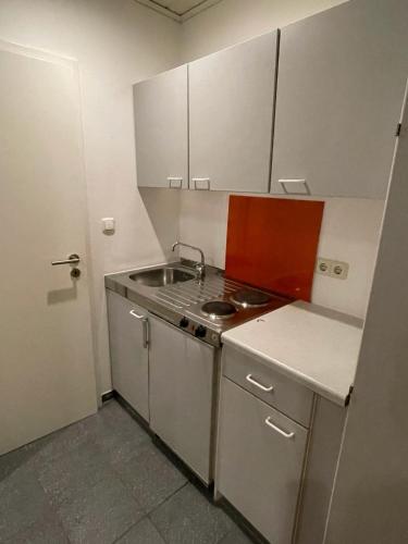 a small kitchen with a sink and a stove at Pension Sonnenschein in Halle an der Saale