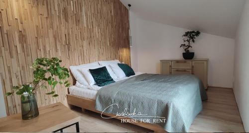 een slaapkamer met een bed en een houten muur bij Cieślówka in Leżajsk