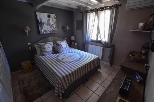 - une chambre avec un lit et une couette à rayures dans l'établissement Villa le 62 Cazan, à Vernègues