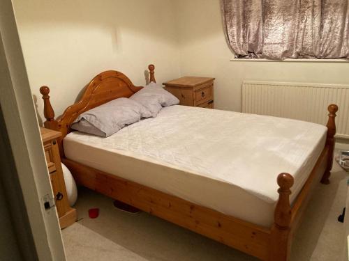 een slaapkamer met een bed met een houten hoofdeinde bij Ramilies Homes in Chatham