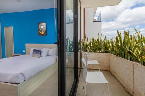 una camera con letto e un balcone con piante di Apartment in Excellent Location a Playa del Carmen